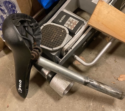 The seat post is lying on the ground. The shaft has a cursory dollop of nasty black grease, and a bunch of dents in the bottom.